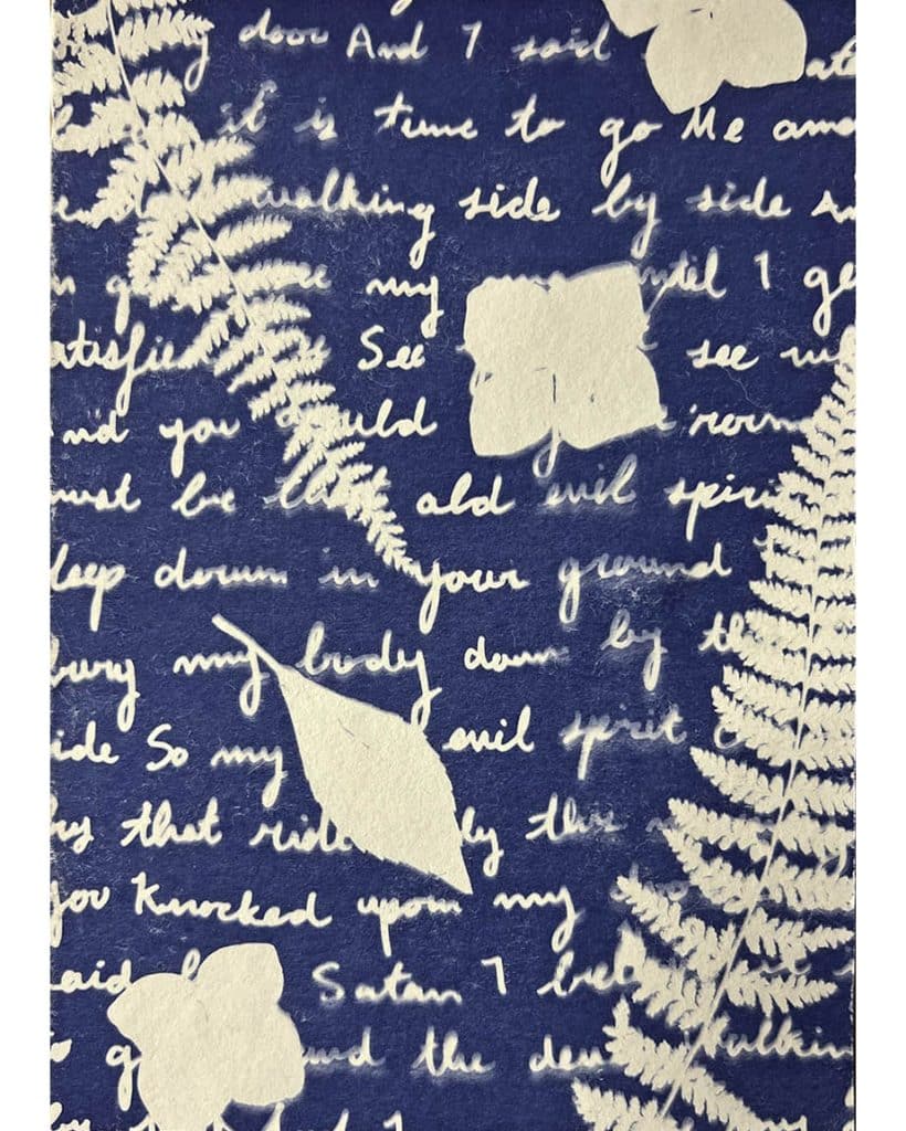 Photo of a blue and white cyanotype featuring words and botanical prints.